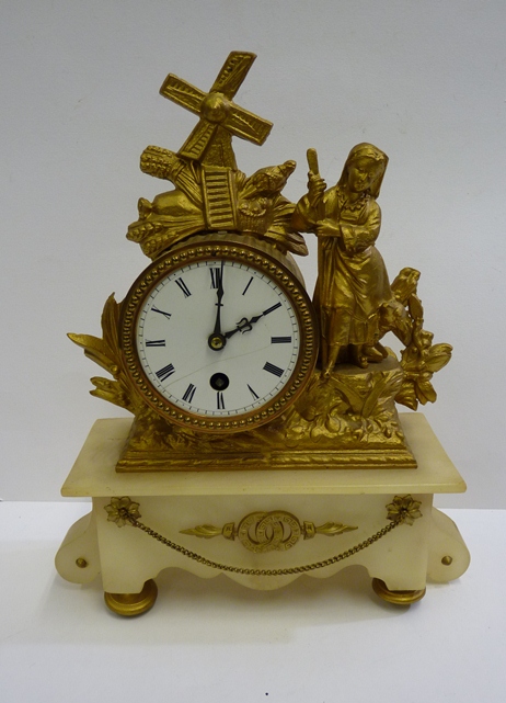 A gilt and alabaster mantle time piece, the drum movement set within a gilt spelter mount of a