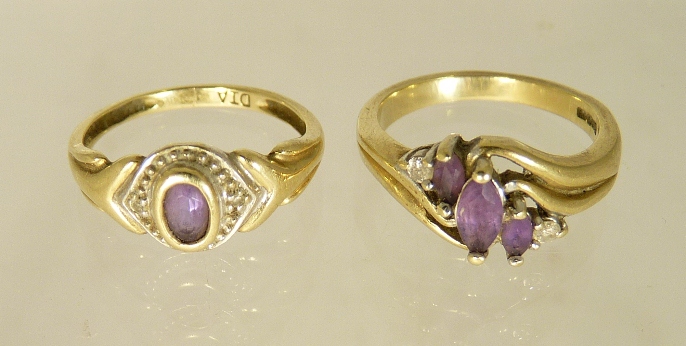 A 9ct gold dress ring set with three oval faceted amethysts and two small diamonds in an open work