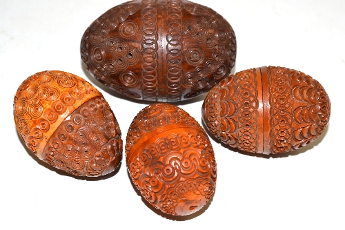 Four carved coquille nuts