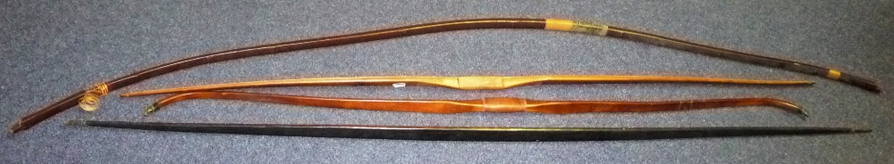 A Japanese Yumi (Bow), the curved flattened section limb covered in a dark red lacquer, with wicker
