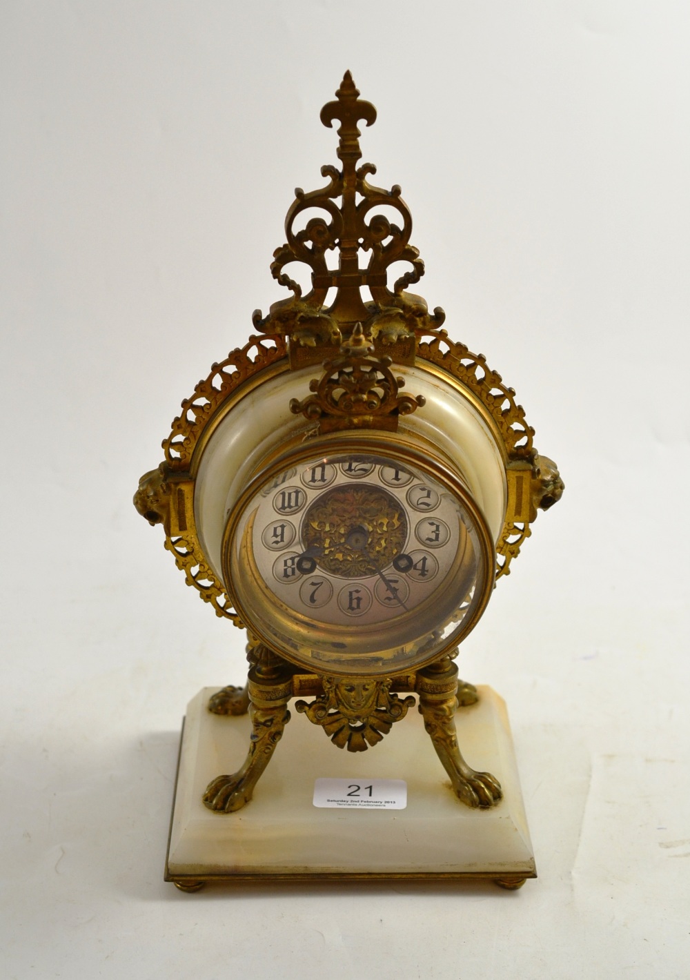 A late 19th century French gilt metal and white marble mantel clock in a circular case