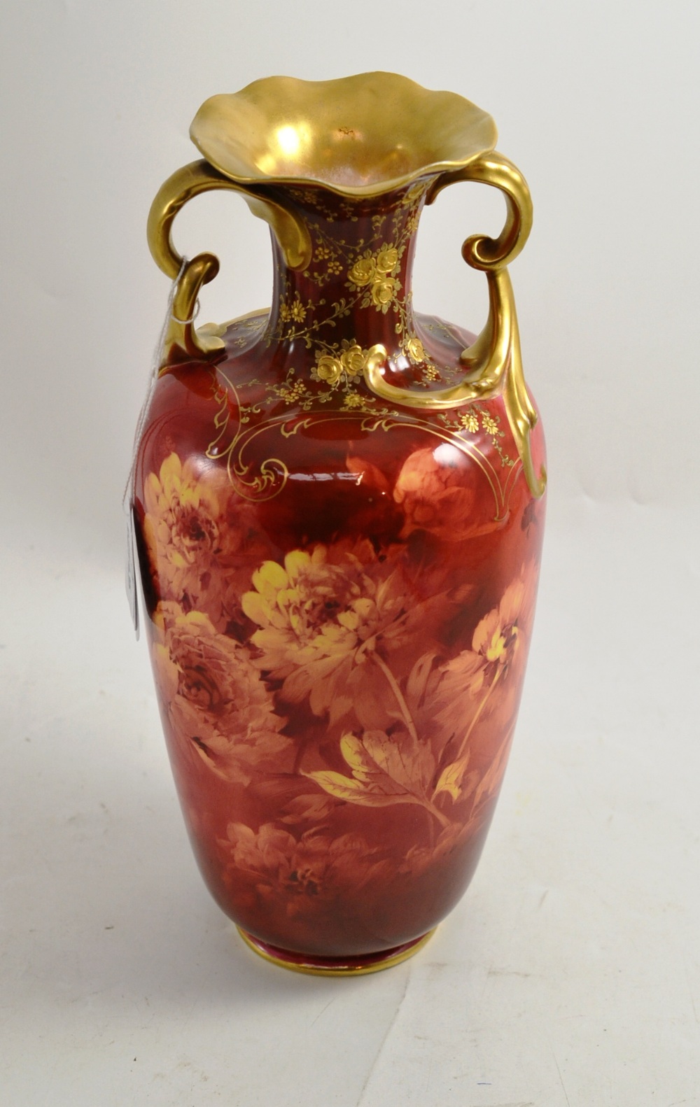 A Doulton Burslem twin handled vase with floral decoration on a red ground