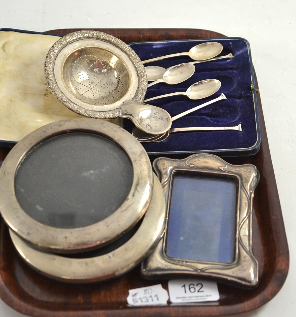 Pair of silver mounted circular frames, silver mounted embossed frame, cased set of silver teaspoons