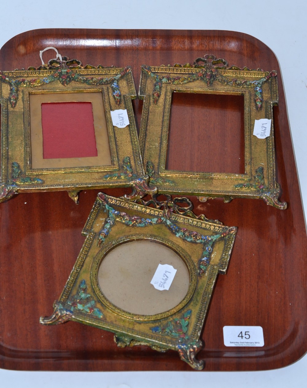 Three gilt metal easel frames with painted decoration