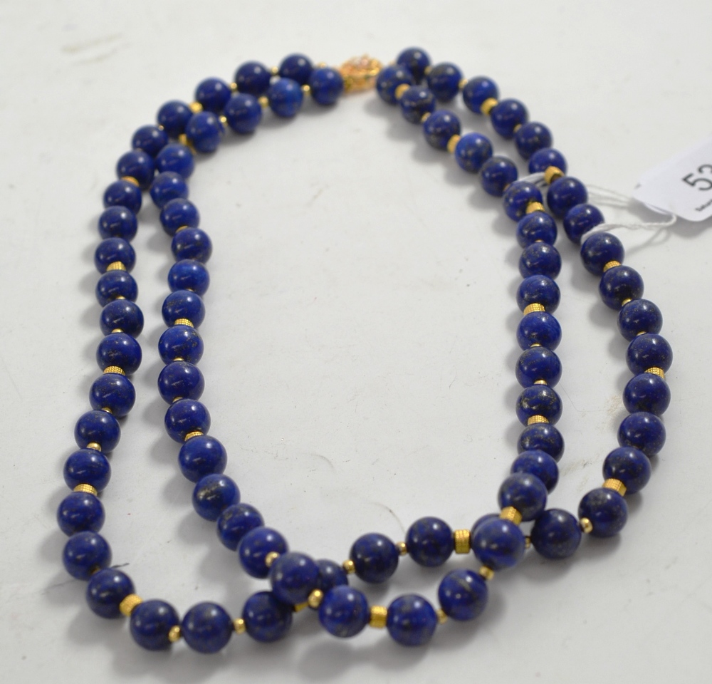 A double strand of lapis lazuli beads with gilt metal spacers