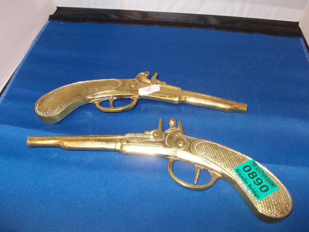A pair of Edwardian Wall mounted Brass Pistols Pistols