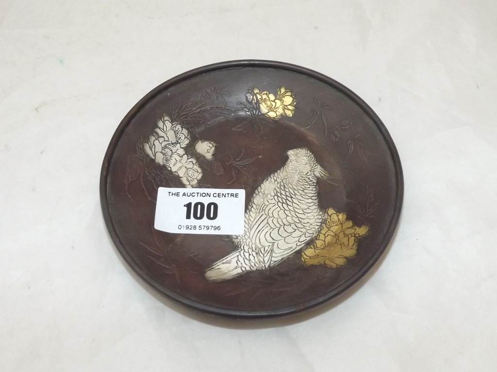 A small bronze bowl depicting a parrot with relief decoration