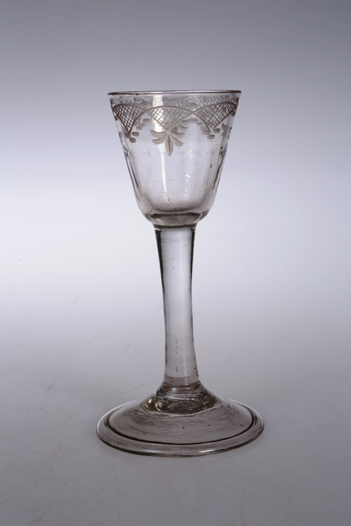 A mid 18th century cordial glass, the bucket bowl etched with trellis and leaves, above a plain stem