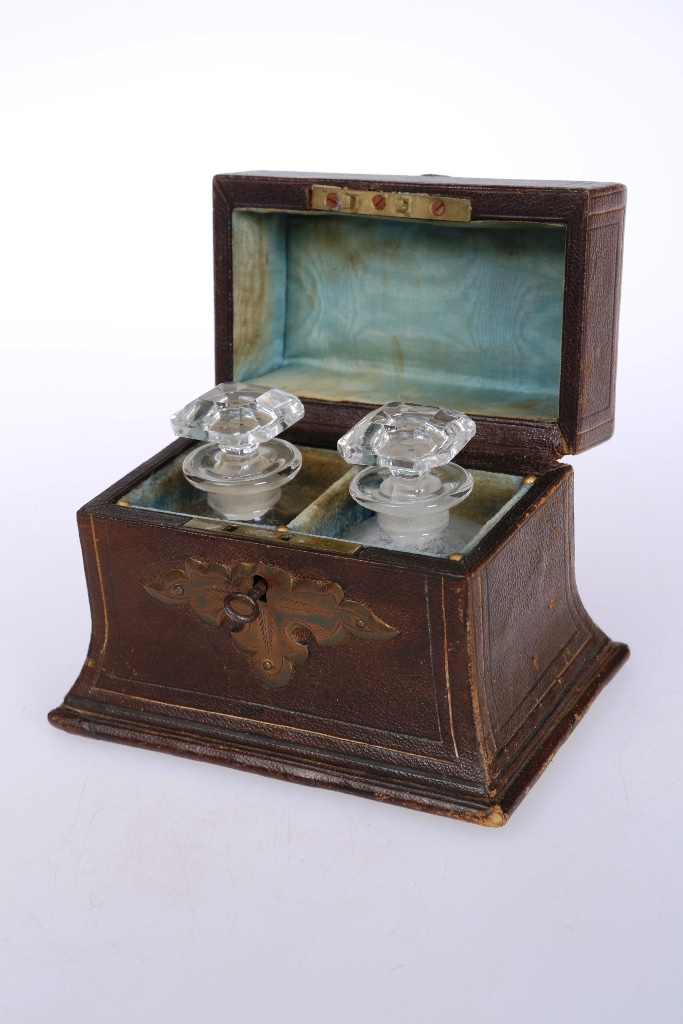 A pair of 19th century scent bottles in a leather travelling case, the hinged rectangular cover with