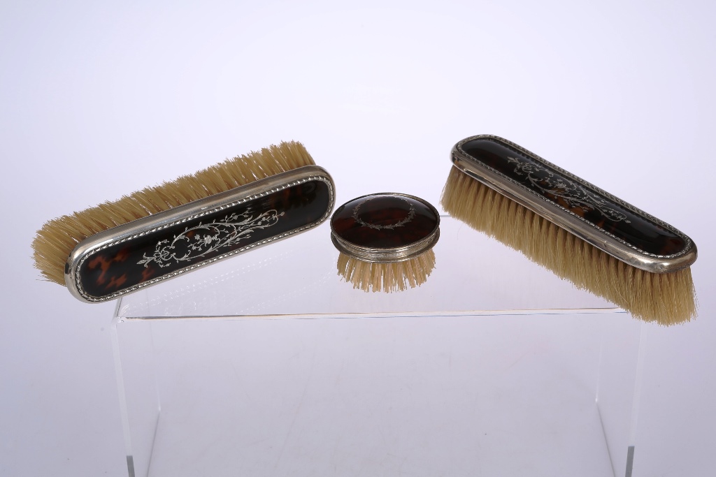 A pair of Edwardian silver and tortoiseshell dressing table brushes, William Comyns, London 1909,