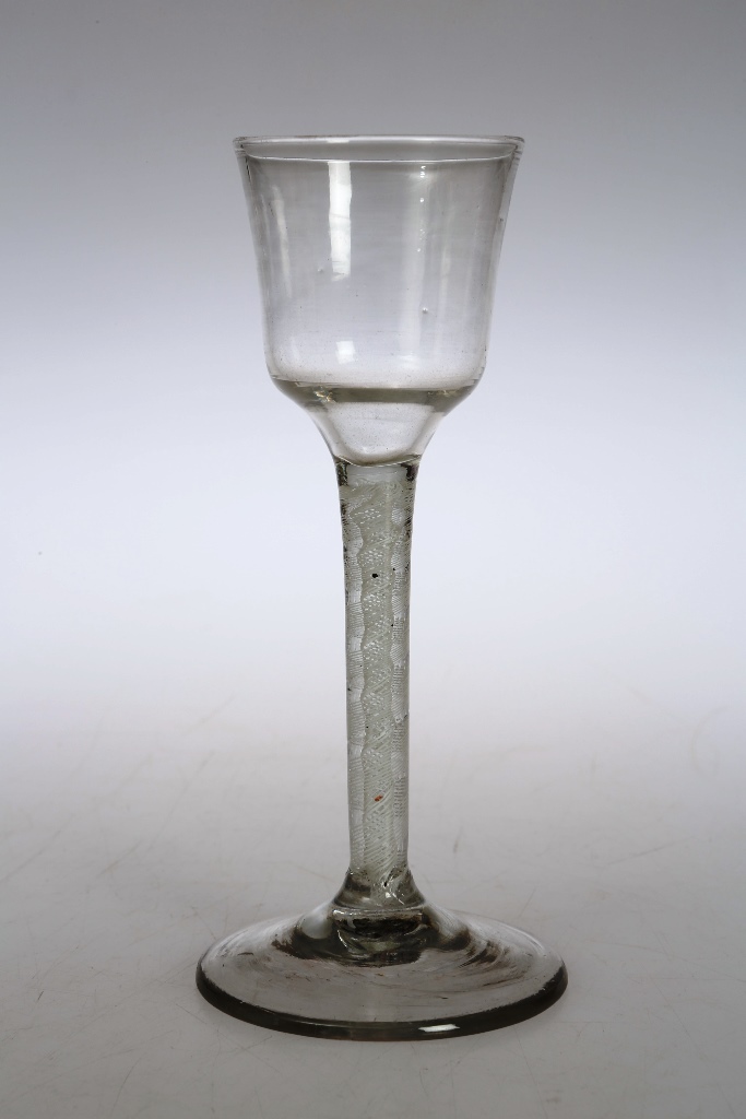 A mid 18th century wine glass, the ogee bucket bowl above a double series opaque twist stem,