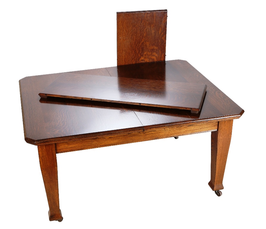 An oak wind-out extending dining table, circa 1910, the moulded top with cut-off corners, above a