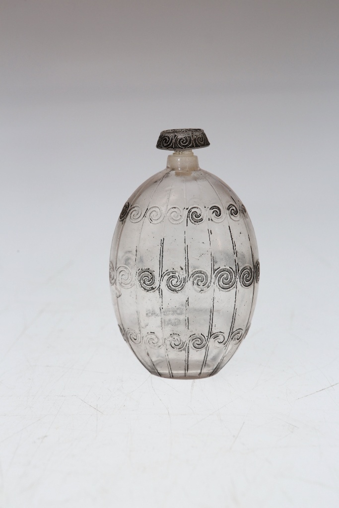 A Lalique perfume bottle, the ovoid body moulded with scrolls and with black staining, moulded Le