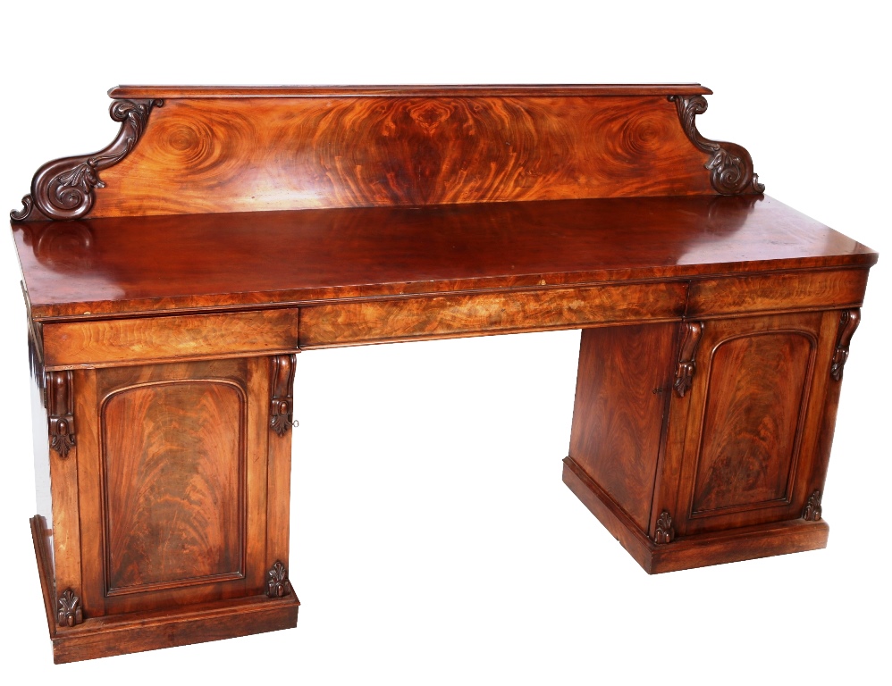 An early Victorian mahogany pedestal sideboard, the backboard with leaf carved scrolls above a