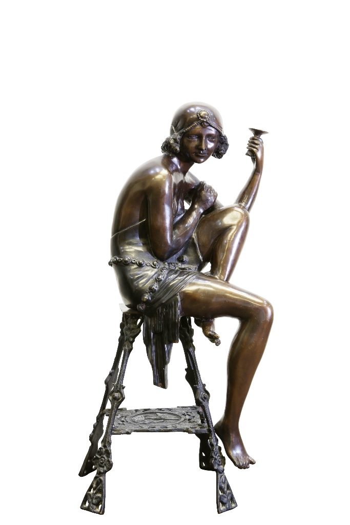 An Art Deco style patinated bronze figure, the scantily clad young lady cast sat upon a table. 67cm