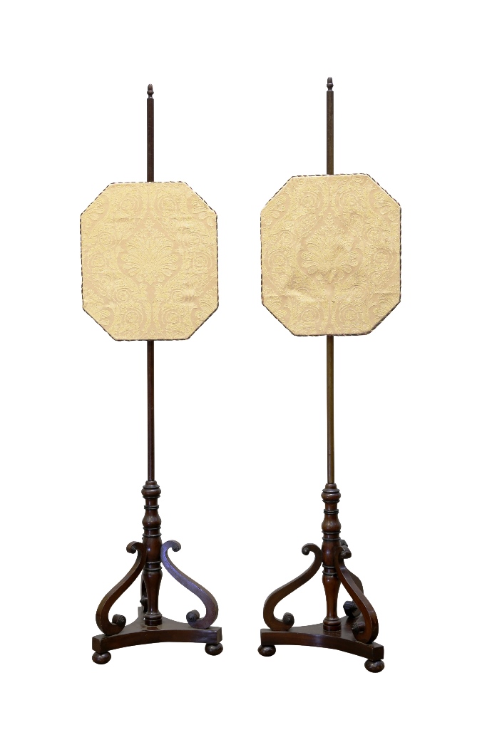 A pair of early 19th century mahogany pole screens, in the manner of Gillows, the acorn topped stems