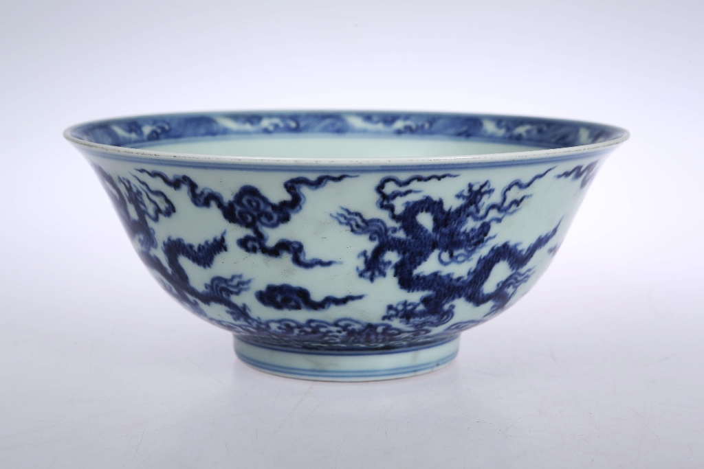 A Chinese porcelain bowl, the interior blue painted with a dragon and flaming pearls, the exterior
