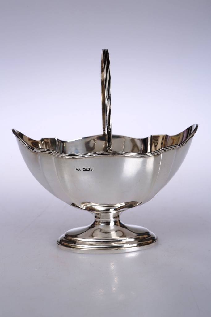 A George V silver sugar basket, Mappin & Webb, Sheffield 1928, of shaped oval form with reeded