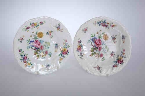 A pair of English porcelain leaf moulded plates, c. 1835, each painted with floral sprays in