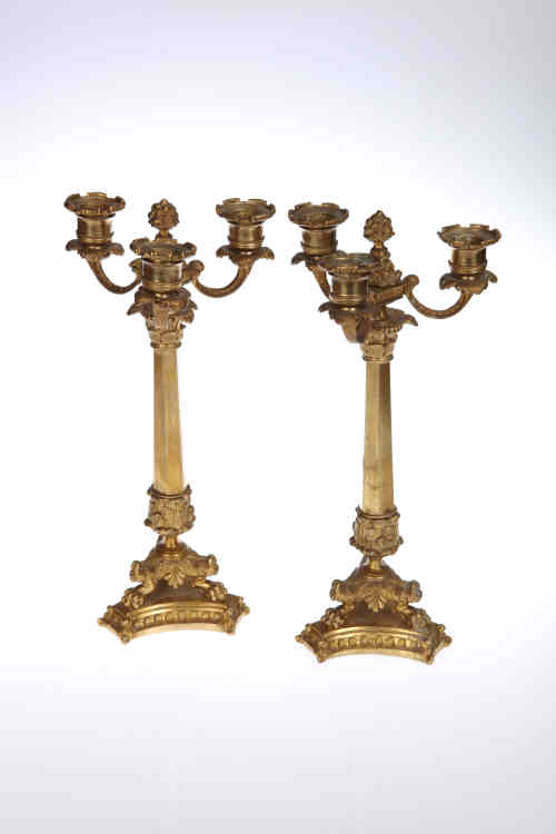 A pair of Empire style gilt bronze candelabra, each candle cup with detachable drip pan above a