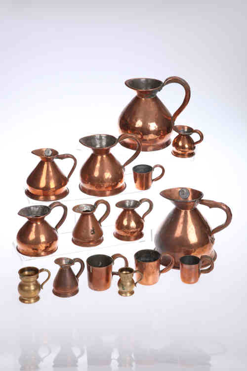 A collection of Georgian and later copper and brass measures.