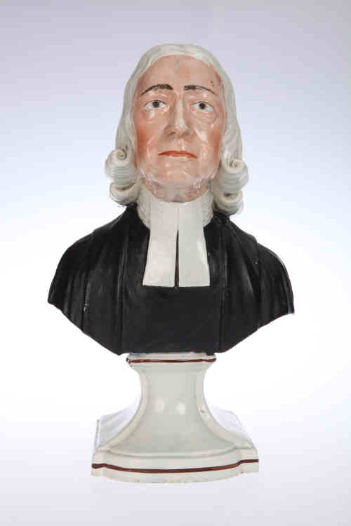 A 19th century Staffordshire pottery bust of John Wesley, modelled on an integral socle with "