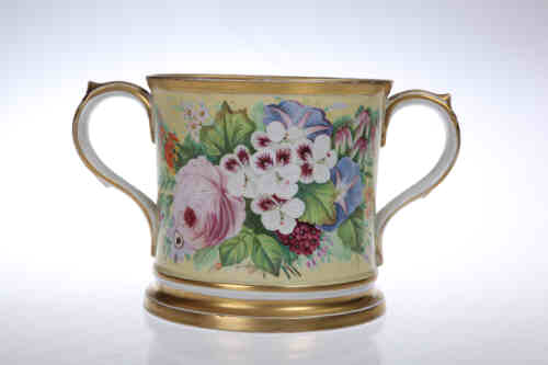 A mid 19th century porcelain loving cup, in the manner of Coalport, painted with flowering foliage