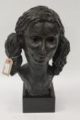 A bronze study of a young girl with pigtails, on black marble plinth, height 45 cm. CONDITION