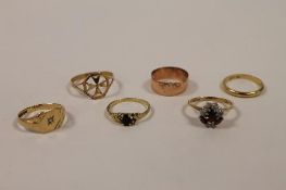 A 14ct gold wedding band, together with five yellow metal rings. (6) CONDITION REPORT: Various metal