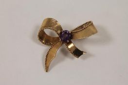 A 9ct gold bow brooch set with an amethyst, 9g. CONDITION REPORT: Good condition.