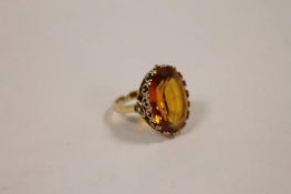 A 9ct gold dress ring  set with an orange gemstone. CONDITION REPORT: Good condition.