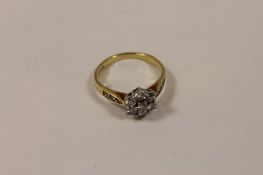 An 18ct gold diamond cluster ring. CONDITION REPORT: Good condition, with three small diamond