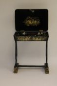 A nineteenth century lacquered work table, the compartmentalised interior containing ivory