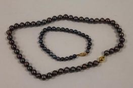 A Tahitian black pearl necklace with 9ct gold clasp, together with a similar bracelet. (2) CONDITION