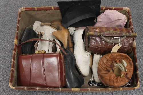 A wicker case containing vintage leather shoes, a crocodile skin handbag, mortar board etc. (Q)