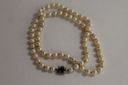 A pearl necklace, with 14ct white gold sapphire mounted clasp, length 60 cm. CONDITION REPORT: