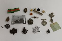 A collection of military cap and lapel badges, together with a WW II defence medal and a whistle. (