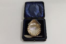 A silver shell butter dish and knife, cased. CONDITION REPORT: The dish is marked Sheffield 1899,