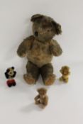 A mid-twentieth century mohair teddy bear, together with three miniature teddy bears. (4)