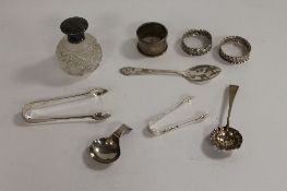 Three silver napkin rings, together with five items of silver cutlery and a silver topped bottle. (