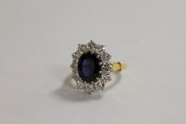 An 18ct gold sapphire and diamond cluster ring. CONDITION REPORT: Super deep blue sapphire