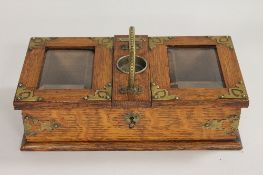 An Edwardian oak and brass mounted table box, width 31 cm. CONDITION REPORT: Possibly a cigarette