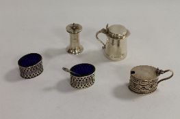 A silver mustard pot, of tankard shape, London 1928, together with four further condiment pots. (