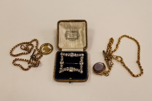 An early twentieth century paste buckle, together with two yellow metal pocket watch chains. (3)