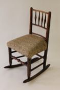 An early nineteenth century oak rocking chair, height 50 cm. CONDITION REPORT: Good condition.