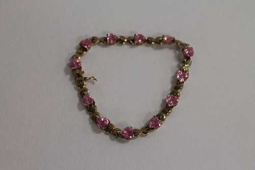 A 9ct gold bracelet set with pink heart shaped zirconia.  CONDITION REPORT: Good condition, gross