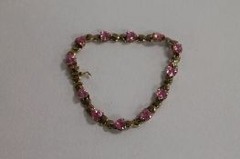 A 9ct gold bracelet set with pink heart shaped zirconia.  CONDITION REPORT: Good condition, gross