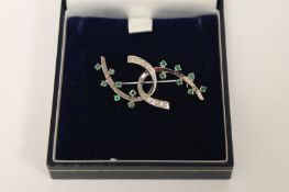A 9ct white gold emerald and diamond broach. Good condition.