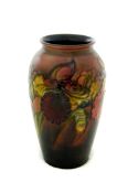 A Moorcroft vase, decorated with amaryllis on red background, height 18.5 cm. Good condition,