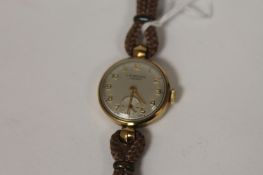 A 9ct gold Lady`s wrist watch by J.W.Benson. Good condition, on leather and cord strap.